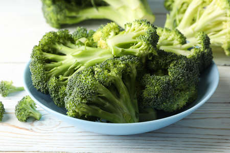 Plate with broccoli on wooden background, close up. Healthy food