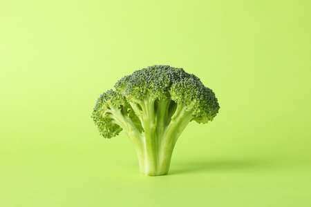 Broccoli on green background, space for text. Healthy food