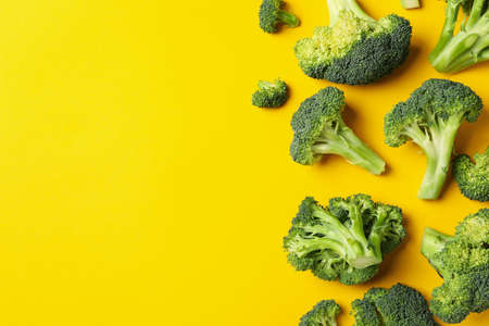 Broccoli on yellow background, top view. Healthy foodの写真素材