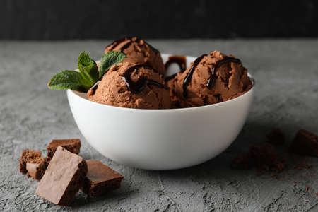 Bowl with ice cream on grey background, close up