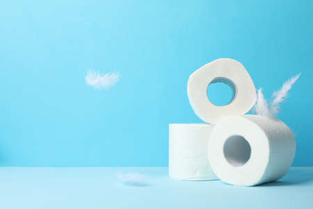 Toilet paper and feathers on blue background, space for textの写真素材