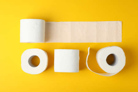 Flat lay with toilet paper on yellow background, top view