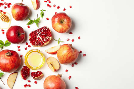 Apple, honey and pomegranate on white background, top view