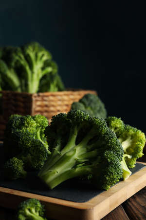 Board and basket with broccoli on wooden background, close upの写真素材