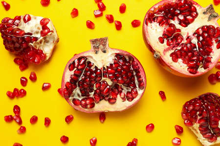 Pomegranate and seeds on yellow background, top viewの写真素材