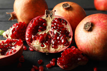 Pomegranate on wooden background, close up. Juicy fruit