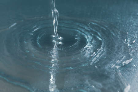 Pouring water on mirror table. Fresh drink water
