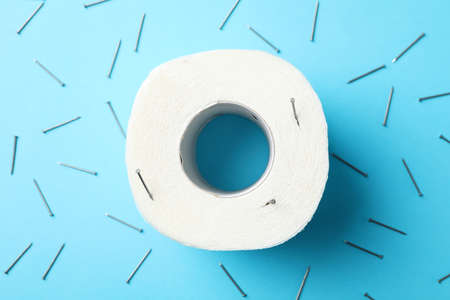 Toilet paper and nails on blue background, top viewの写真素材