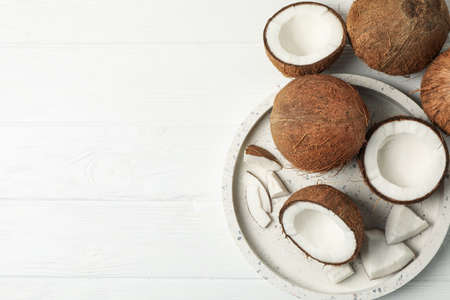 Tray with coconut on wooden background, top view. Tropical fruitの写真素材