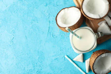 Coconut and milk on blue background, top view
