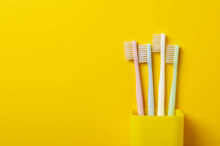 Toothbrushes on yellow background, space for textの写真素材