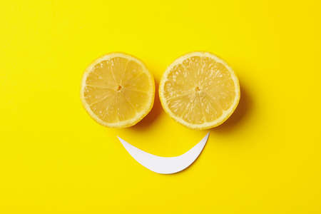Smiley face made of lemons on yellow backgroundの写真素材