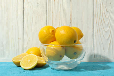 Bowl with lemons on blue table. Ripe fruitの写真素材