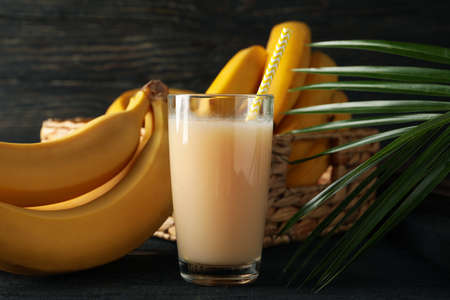 Bananas, juice and palm branch on wooden background. Fresh fruitの写真素材