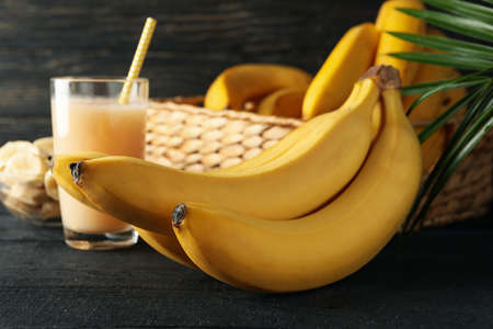 Bananas, juice and palm branch on wooden background. Fresh fruitの写真素材