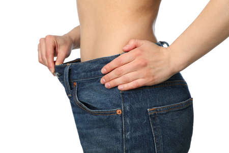 Girl pulling her big jeans and showing weight loss, isolated on white background