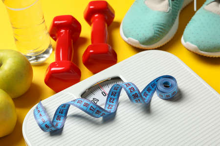 Weight loss or healthy lifestyle accessories on yellow backgroundの写真素材