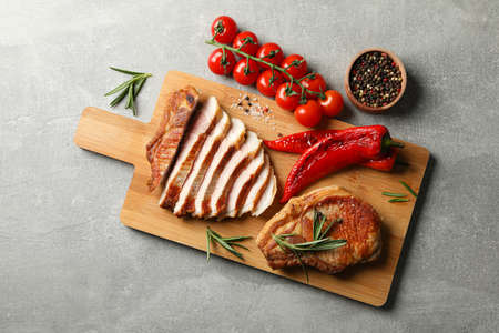 Board with fried steaks on gray background. Grilled foodの写真素材