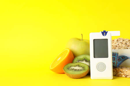 Blood glucose meter and diabetic food on yellow backgroundの写真素材