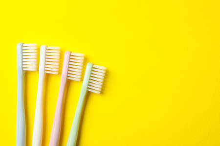 Toothbrushes on yellow background, space for textの写真素材