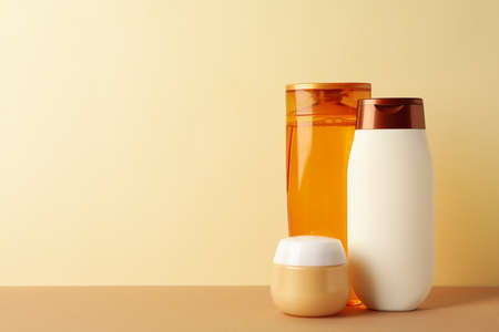 Blank cosmetic bottles on beige background, space for textの写真素材