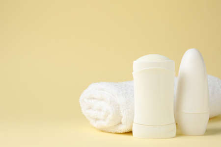 Body deodorants and towel on beige background, space for textの写真素材