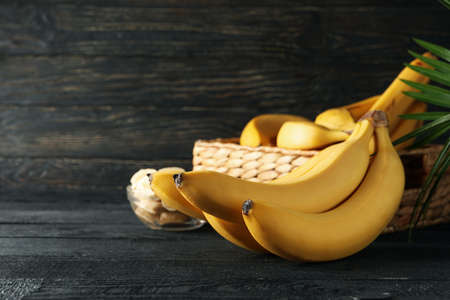 Bananas. Basket with bananas and bowl with slices on wooden backgroundの写真素材