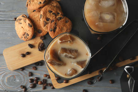 Composition with ice coffee and cookies on wooden background