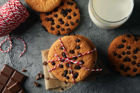 Composition with chip cookies and milk on gray table