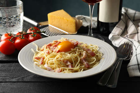 Composition with plate of tasty pasta and wine on wooden backgroundの写真素材