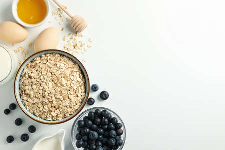 Composition with oatmeal flakes on white background, top view. Cooking breakfastの写真素材