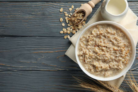 Composition with oatmeal porridge on wooden background. Cooking breakfast