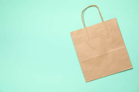 Blank paper bag on mint background, space for textの写真素材