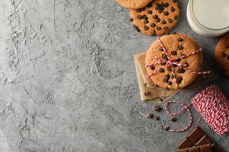 Composition with chip cookies and milk on gray table