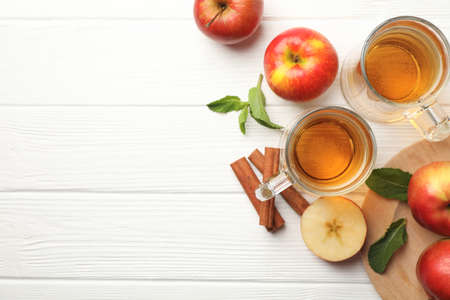 Composition with cider, cinnamon and apples on white wooden backgroundの写真素材