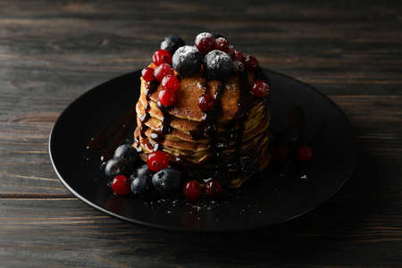 Plate with pancakes and berries on wooden background. Sweet breakfastの写真素材