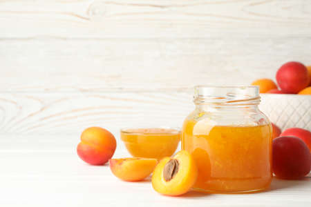 Composition with tasty apricots and jam on white wooden tableの写真素材