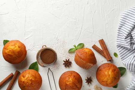 Composition with muffins and cinnamon on white background