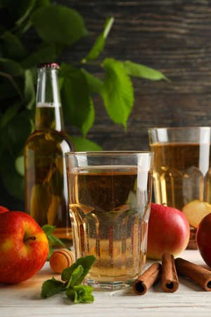 Composition with cider, cinnamon and apples on wooden background