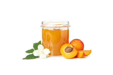 Glass jar with jam and apricots isolated on white backgroundの写真素材