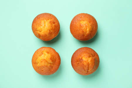 Flat lay with tasty muffins on mint background, top viewの写真素材