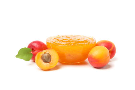 Glass bowl with jam and apricots isolated on white backgroundの写真素材