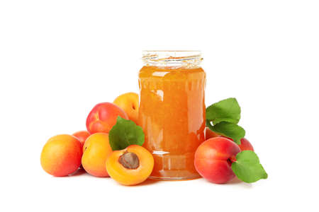 Glass jar with jam and apricots isolated on white backgroundの写真素材
