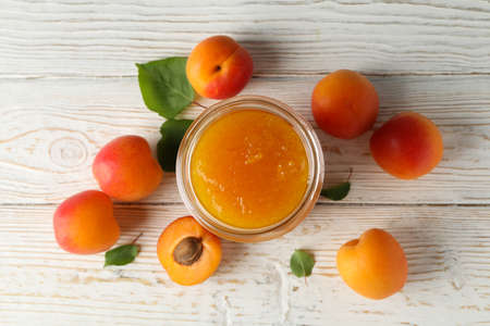 Composition with tasty apricots and jam on wooden tableの写真素材