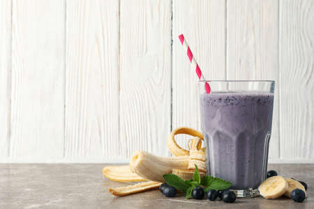 Glass of berry milkshake on gray table. Summer drinkの写真素材
