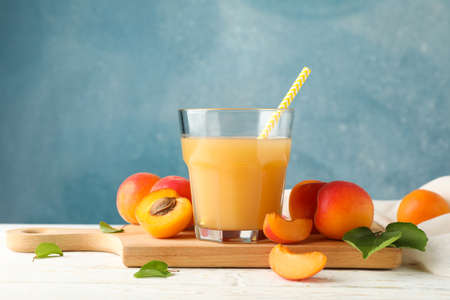 Composition with tasty apricots and juice on wooden tableの写真素材