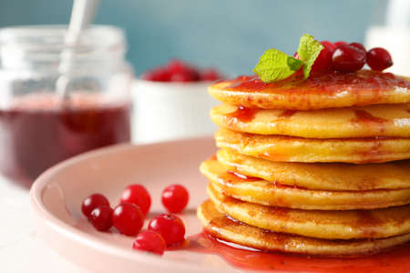 Pancakes with jam and cranberry, close up. Sweet breakfast