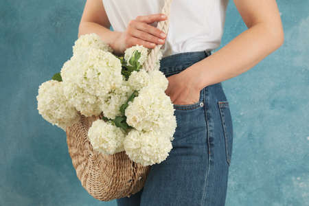 Beautiful fashionable woman with hydrangea flowers. Spring plant