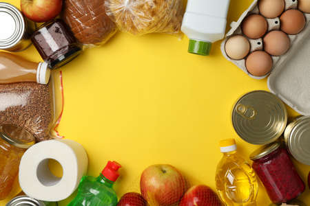 Different food on yellow background, top view. Donation concept