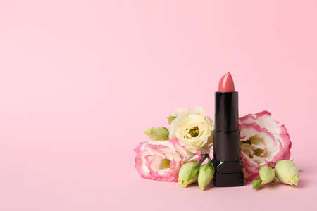 Lipstick and flowers on pink background. Female accessoriesの写真素材